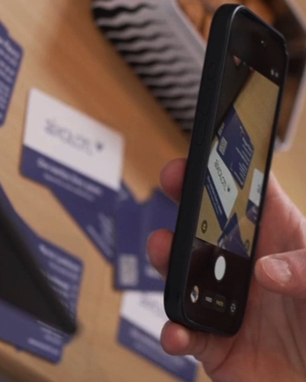 Guest photographing printed cards on a table with a phone